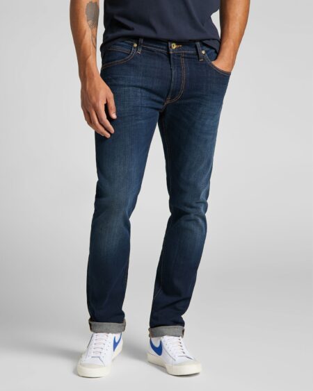 Jeans Luke Slim Tapered , Dark Blue - LEE. Ανδρικό ελαστικό τζιν παντελόνι σε νεανική γραμμή. Άνετη εφαρμογή, καθώς είναι κανονικό μέχρι το γόνατο και στενεύει από τη μέση της γάμπας μέχρι το τελείωμα. Επιπλέον, είναι από μαλακό ύφασμα και κλείνει στο καβάλο με φερμουάρ.  Το χρώμα του είναι μπλε σκούρο με ελαφρύ ξέβαμμα και ταμπά ραφές. Γραμμή δοκιμασμένη και εδραιωμένη από το κοινό σε απόχρωση που συνδυάζεται εύκολα όλες τις εποχές. Σύνθεση 93% cotton, 5% polyester, 3% elastane