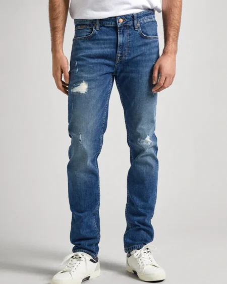 Men Mid Rise Slim Jeans WORN Medium Blue. Ανδρικό παντελόνι τζιν σε στενή γραμμή και μεσαίο καβάλο. Μέτριο μπλε με έντονες φθορές. Μαλακό και ελαστικό ύφασμα. Νεανικό και casual ύφος.