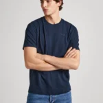 Men Cotton Regular T-Shirt CONNOR Navy. Ανδρικό μακό μπλουζάκι με κοντό μανίκι και στρόγγυλο λαιμό. Μαλακό και ελαφρύ βαμβακερό ύφασμα που αναπνέει. Casual και minimal outfit σε κάθε εποχή. Ιδανικός συνδυασμός denim & cotton chinos παντελόνια. PRODUCT DETAILS - Cotton jersey T-shirt – Regular Fit - Short sleeves - Crew neck - PEPE JEANS logo embroidered on the chest - Ribbed detail on the neck - Double stitching on sleeves and hem - Inner neck band with printed logo - Made of 100% sustainable cotton. Sustainable cotton minimises the use of harmful chemicals, improves soil quality, and prevents contamination to help protect the health of growers and local wildlife.