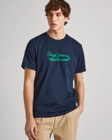 Men Cotton Regular Logo T-Shirt CLAUDE Navy. Ανδρικό μακό μπλουζάκι με κοντό μανίκι και στρόγγυλο λαιμό. Μαλακό και ελαφρύ βαμβακερό ύφασμα που αναπνέει. Casual outfit σε κάθε εποχή. Ιδανικός συνδυασμός denim & cotton chinos παντελόνια. PRODUCT DETAILS - Cotton jersey T-shirt – Regular Fit - Short sleeves - Crew neck - PEPE JEANS logo printed on chest- Ribbed detail on the neck - Double stitching on sleeves and hem - Inner neck band with printed logo - Made of 100% sustainable cotton. Sustainable cotton minimises the use of harmful chemicals, improves soil quality, and prevents contamination to help protect the health of growers and local wildlife.