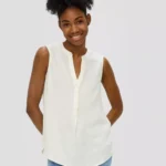 Woman Sleeveless Crêpe Blouse Ecru. Γυναικεία μπλούζα αμάνικη με V γραμμή και κουμπάκια στη λαιμόκοψη. Ελαφρύ και αέρινο γκοφρέ ύφασμα. Casual ύφος κατάλληλο για καθημερινή χρήση. DETAILS Texture : crêpe texture Neckline : notch neckline Fastener : button placket Sleeves : sleeveless Details : gathered/gathering Back : longer at the back Hem : rounded hem. Fit : Regular Fit Back length : Approx. 67.5 cm in size 36. MATERIAL Quality : lightweight, flowing MATERIAL COMPOSITION Outer fabric: 100% Polyester.